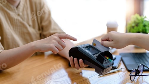 Aperçu: Close up of woman hand using credit card swiping machine to pay.