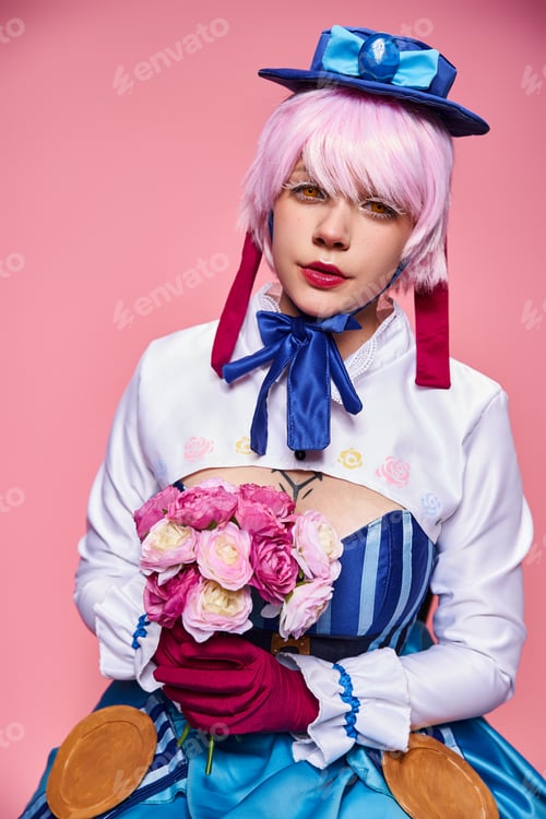 Preview: cute jolly female cosplayer in bright anime costume holding pink flowers and looking at camera
