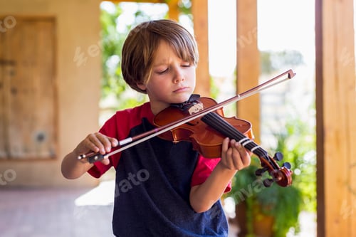 Preview: 6 year old boy playing violin outside in garden