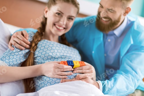 Preview: pregnant woman holding colorful cubes with word girl