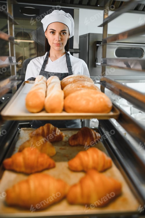 Preview: Baker placing tray of freshly baked bread and croissants in oven