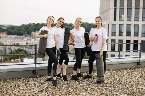 Preview: Women posing with yoga mats and water bottles on rooftop