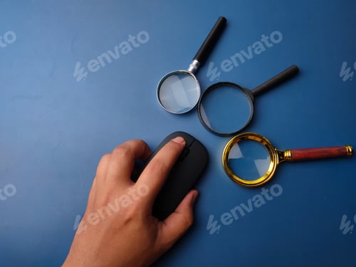 Preview: Someone hand holding black wireless mouse with magnifying glass
