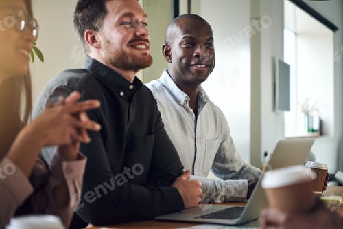 Preview: Diverse businesspeople smiling while sitting together in a boardroom