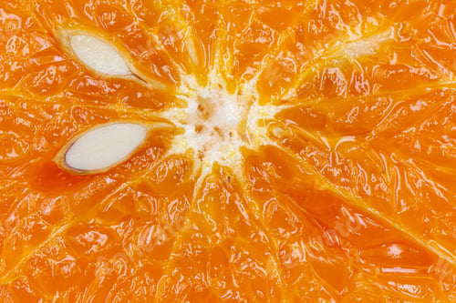 Preview: Oranges on a black background. One orange is cut in half, the other is whole.