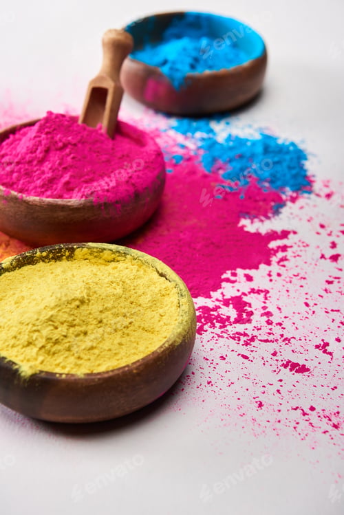 Preview: wooden spatula and bowls with multicolored holi powder on white background