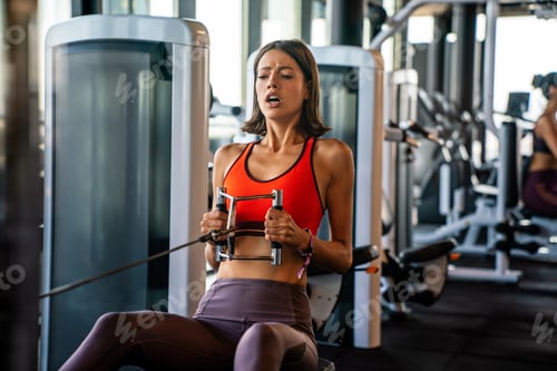 Preview: Attractive young sporty woman is working out in gym