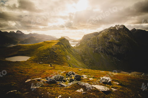 Preview: Idyllic landscape of Norway's Lofoten Islands with lush grassy valleys surrounded by serene waters
