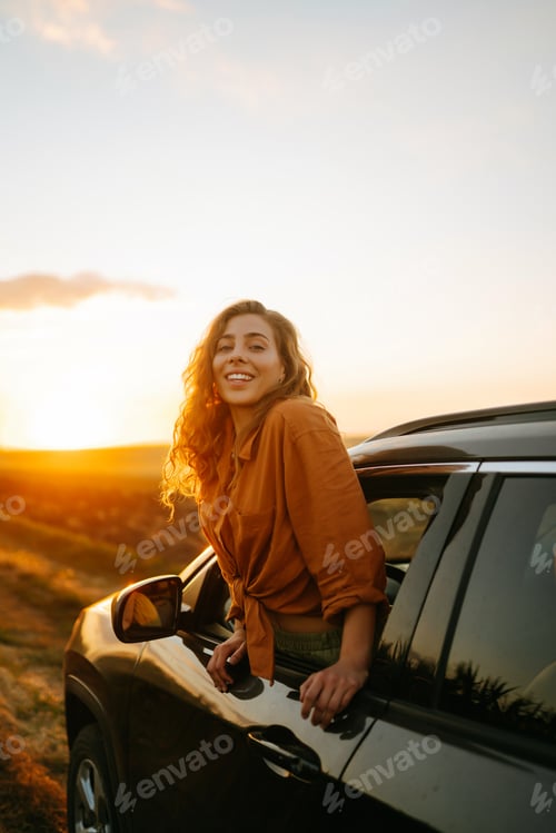 Preview: Young woman is resting and enjoying sunset in car. Lifestyle, travel, tourism, nature, active life.