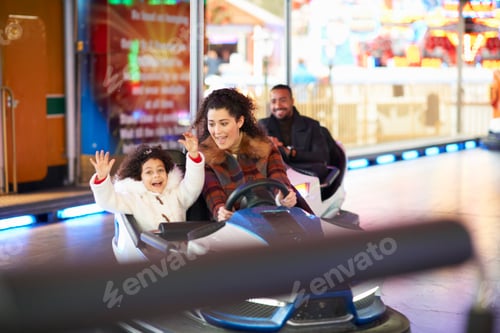 Preview: Mother and daughter in bumper car arms raised smiling