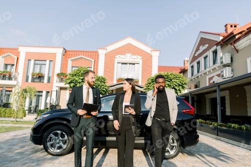 Preview: Group of three young multiethnical business people discussing ideas at meeting outside, walking on