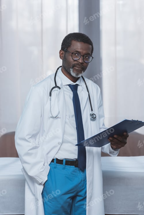 Preview: middle aged african american doctor standing with clipboard