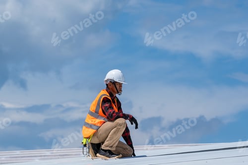 Preview: Roofer worker in protective uniform wear and gloves working installing metal sheet on top roof.