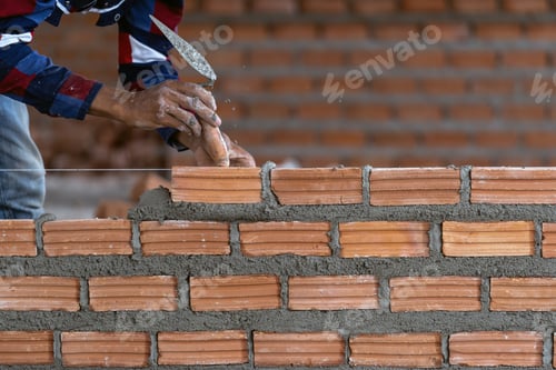 Preview: Closeup hand professional construction worker laying bricks in new industrial site