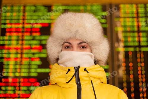 Preview: Woman passenger at railway station, board with departure routes on background