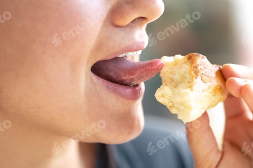Preview: Detailed shot of a woman eating fresh bun.