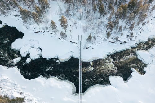 Preview: Aerial view of a bridge over a snow-covered river in Lapland