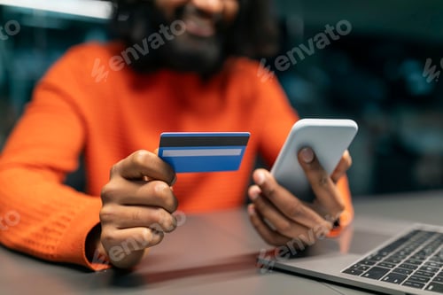 Preview: Cropped of eastern man using phone, credit card at office