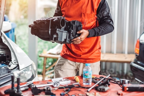 Preview: Close up photo of auto mechanic worker working in garage. Workshop car engine repair service