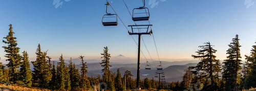Preview: Ski lift ascending up the side of Mount Hood
in Oregon surrounded by fir forest trees at sunset