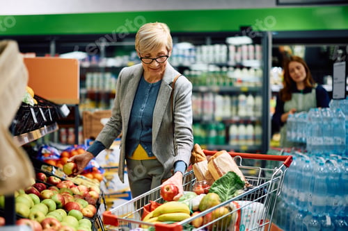 Preview: Senior woman buying fresh fruit at grocery store.