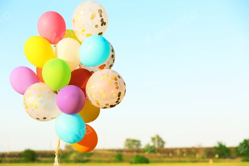Preview: Many colorful balloons against blue sky on sunny day