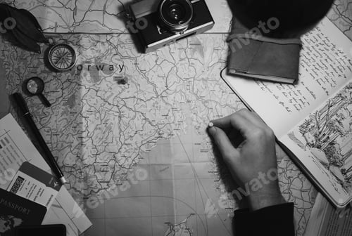 Preview: Aerial view of hand pinning on world map journey travel grayscal