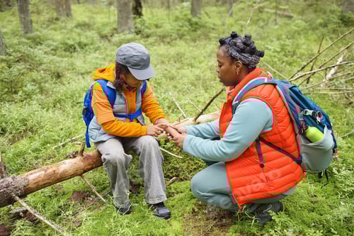 Preview: Black Woman Comforting Sad Child While Sitting Together in Forest Outdoors
