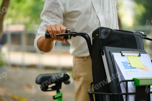 Vorschau: Geschossener Geschäftsmann läuft mit Fahrrad durch den Stadtpark
