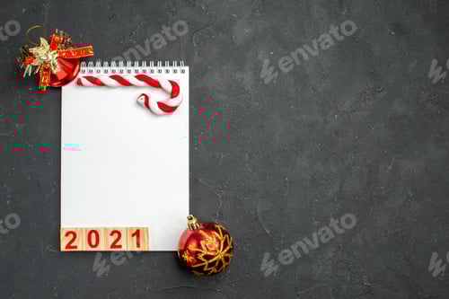 Visualização: vista superior, escrita vermelha no bloco de notas com brinquedos em cor de fundo escuro, feriado, foto de natal, ano novo, grátis