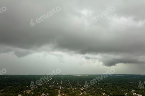 Preview: Dark stormy clouds forming on gloomy sky before heavy rainfall over suburban town area