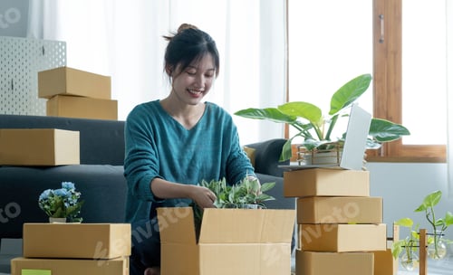 Preview: Young woman small business owner working at home office. Online marketing packaging delivery