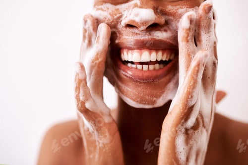 Preview: Studio shot of an unrecognizable woman washing her face against a white background