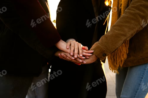 Preview: Close up of unrecognisable people stacking hands as a symbol of unity, community and friendship.