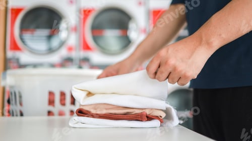 Preview: Man doing launder holding basket with dirty laundry of the washing machine in the public store.