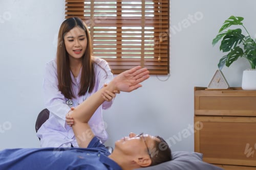 Preview: Healthy concept, Senior man lying on bed doing physiotherapy and stretching arm by woman caregiver