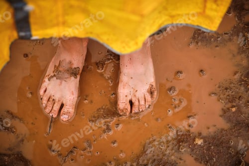 Preview: Dirty feet of crop person in puddle