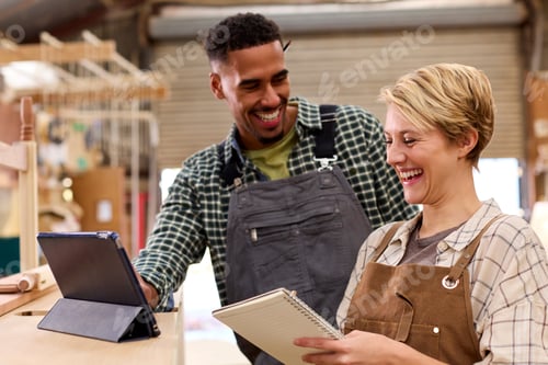 Preview: Male And Female Apprentices With Digital Tablet Working As Carpenters In Furniture Workshop