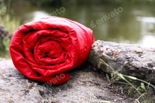 Preview: Rolled sleeping bag outdoors on sunny day