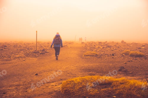 Preview: Woman hiking in new zealand in mordor during dust wind storm outdoors adventure
