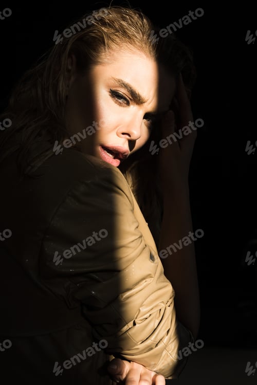 Preview: side view of emotional fashionable woman in trench looking at camera