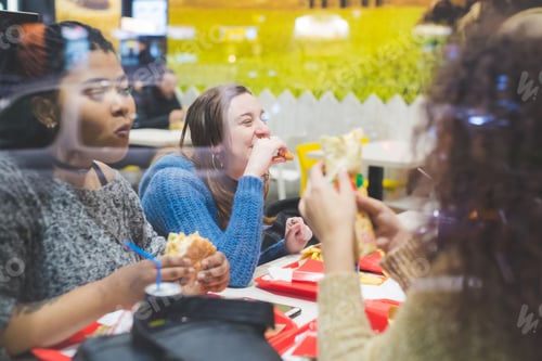 Preview: group of young women eating together in fast food