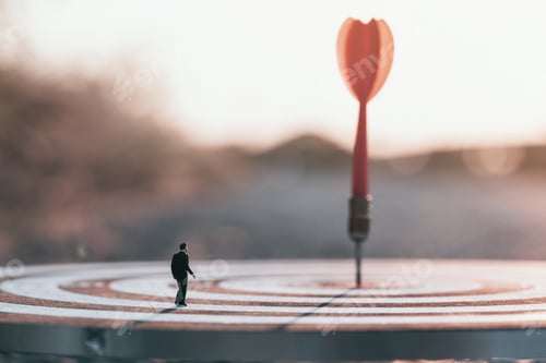 Preview: Businessman standing lookup blurred or out of focus red dart arrow hitting target centre dartboard