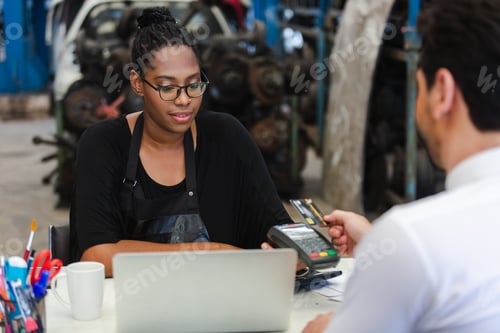 Preview: Female African American car auto parts owner Accepting credit card