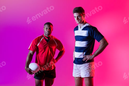 Preview: Portrait of diverse male rugby players with rugby ball over pink lighting
