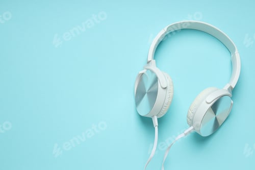 Preview: White, over-the-ear headphones with a wire on a blue background.