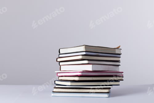 Preview: Close up of stack of books and notebooks with copy space on white background