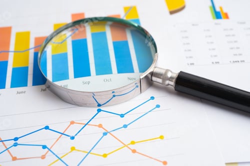 Preview: Magnifying glass on spreadsheet and graph paper. Financial development, Banking Account, Statistic