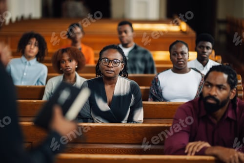 Preview: Group of people sitting in church pews listening to sermon
