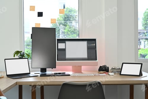 Preview: Creative office studio interior with laptop, blank screen computer, digital tablet.
